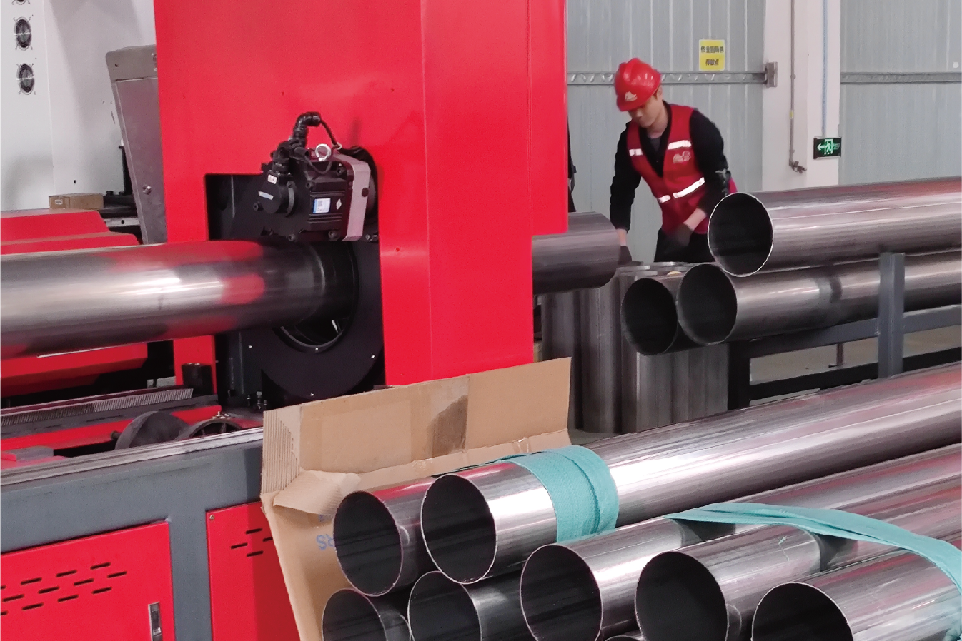 Large-diameter stainless steel pipes being processed by MZBNL’s laser tube cutting machine. Operators ensure smooth workflow and high-efficiency loading.