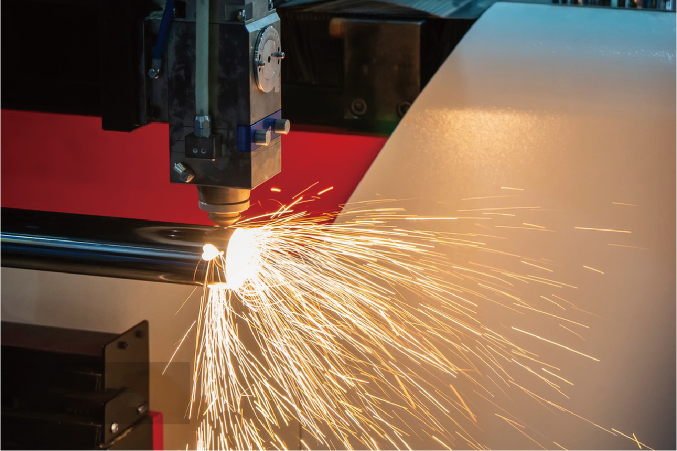 Precision laser cutter slicing stainless tube with high temperature and consistent spark trajectory.