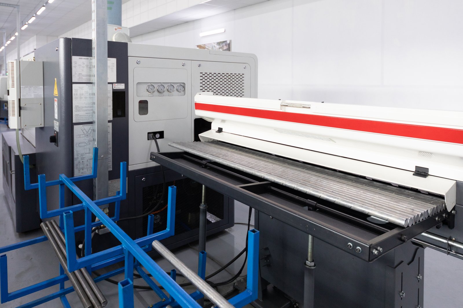 Pipe laser cutting machine with CNC control interface in an industrial workshop. Shows real-time system display and heavy-duty track layout.