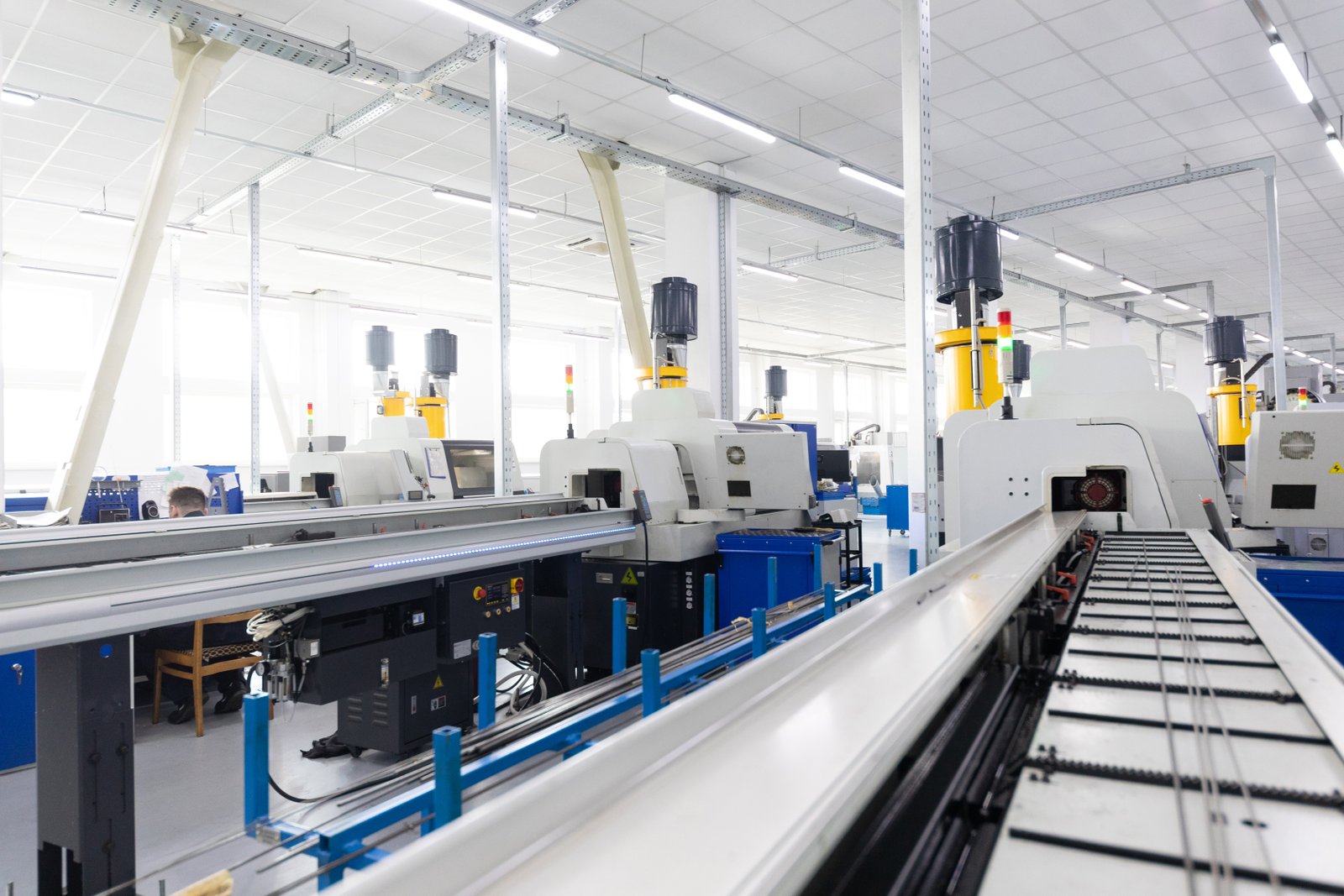Close-up view of automatic bar feeder connected to CNC turning center. Smooth raw material supply ensures uninterrupted production.