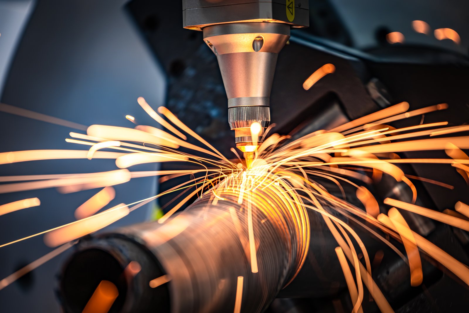 Round steel pipe laser cutting with spiral sparks. MZBNL laser head ensures high precision for industrial-grade pipe manufacturing
