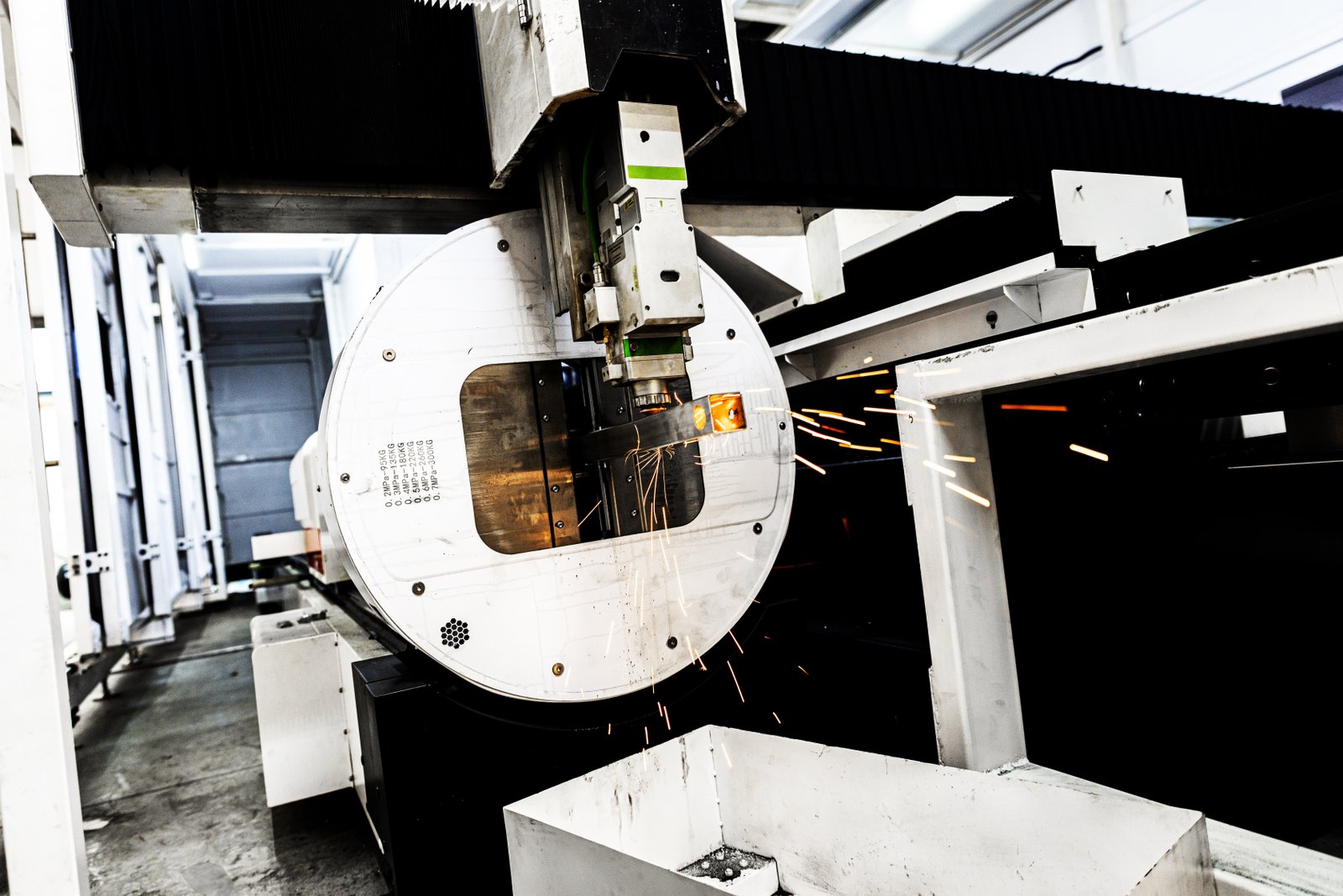 Powerful laser beam cutting metal square pipe with high-precision motion.