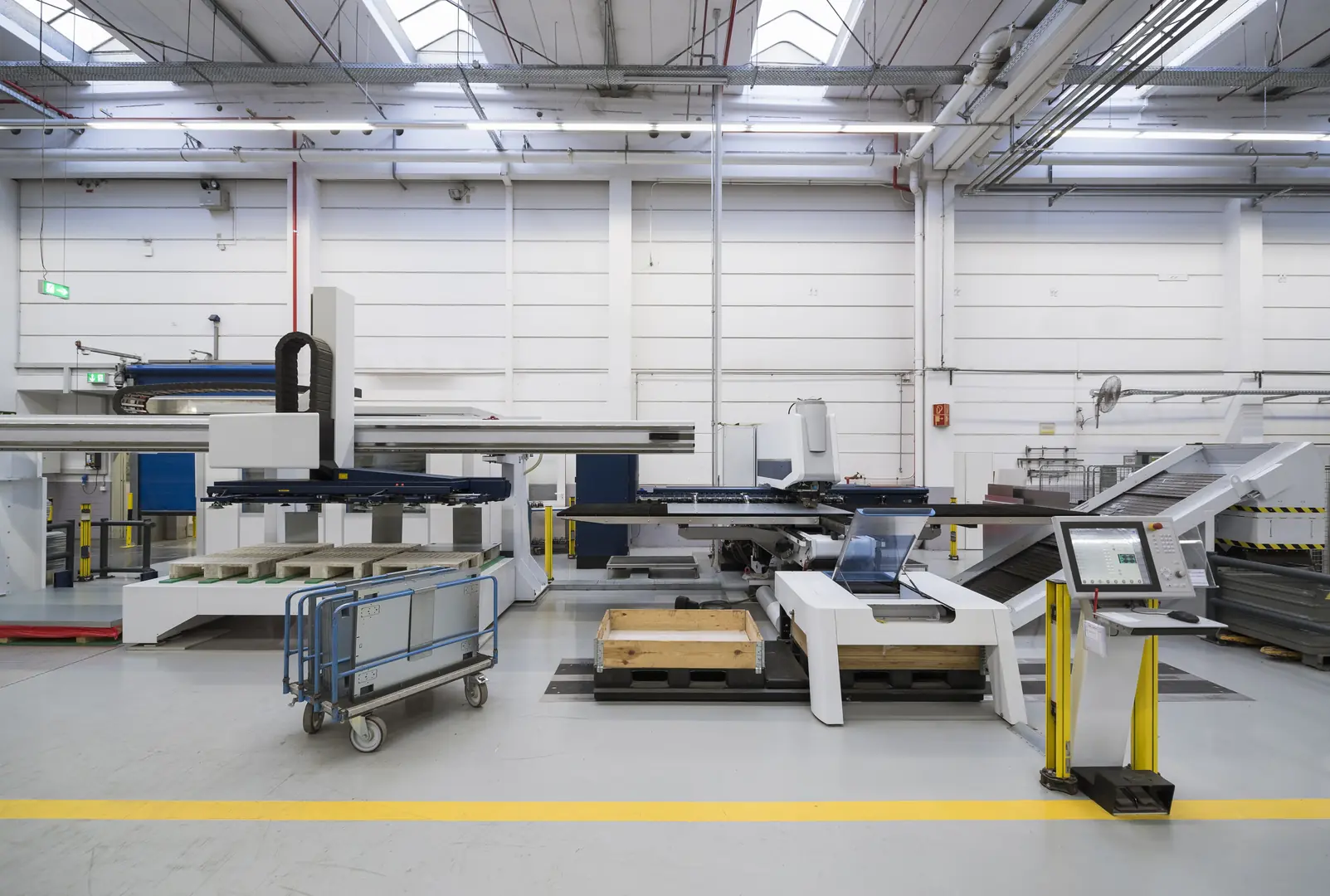 Industrial laser tube cutting machine in modern manufacturing facility with control panel and automated systems