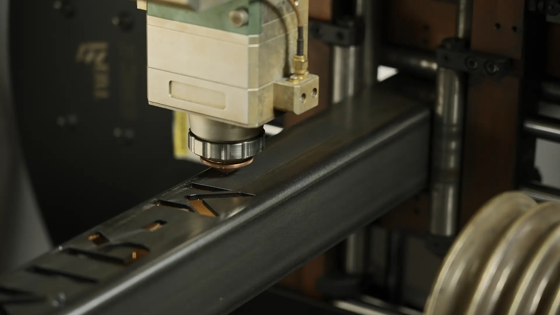 Close-up of high-tech laser cutting machine processing metal tube with precision